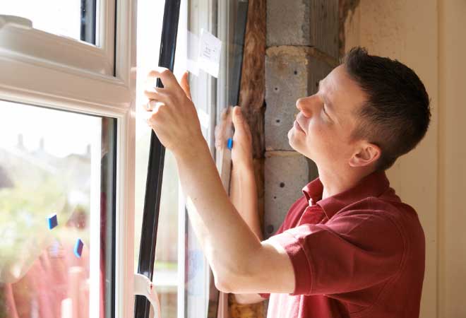 Person installing a window in a home.