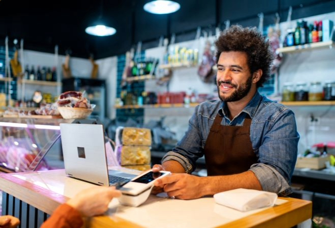 A happy small business owner accepting payment from a customer.