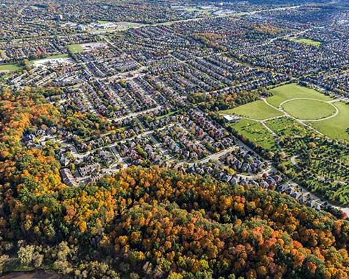 Drone shot of Halton Region showing homes and forested areas