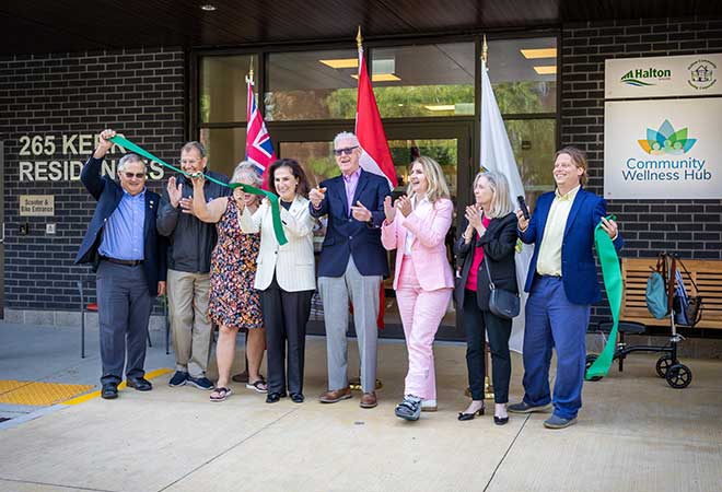 A group of politicians cutting a ribbon in front of the 265 Kerr Street Residences.