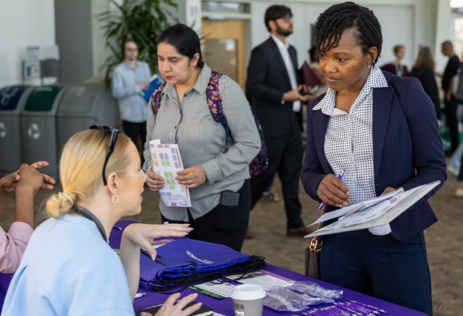 A job seeker speaks with a job fair attendant.