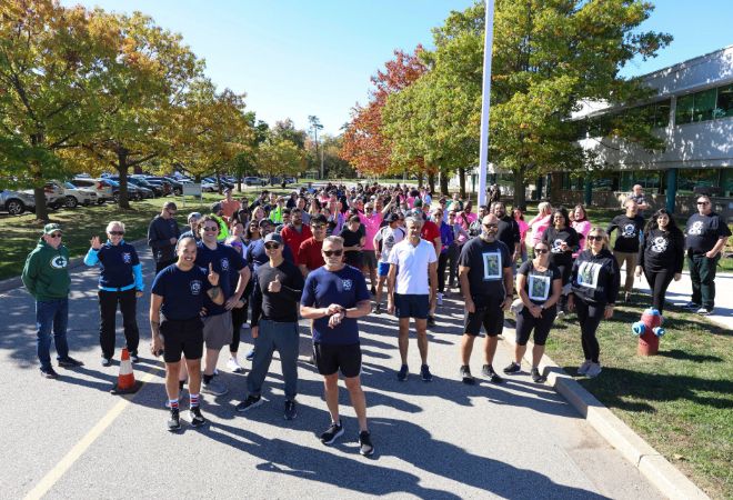 A smiling group of staff in athletic wear standing outside Halton Regional Centre.