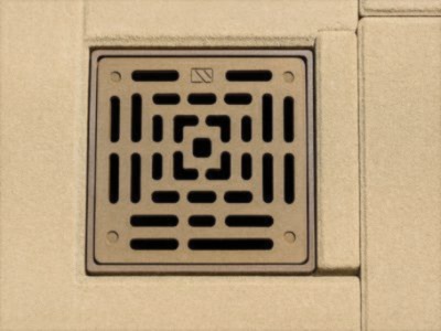 A drain inset in a stone patio.