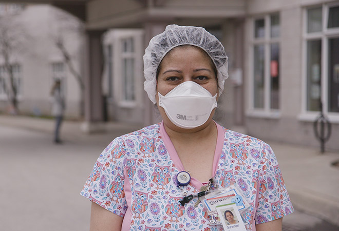 nurse standing and facing the camera with face mask on
