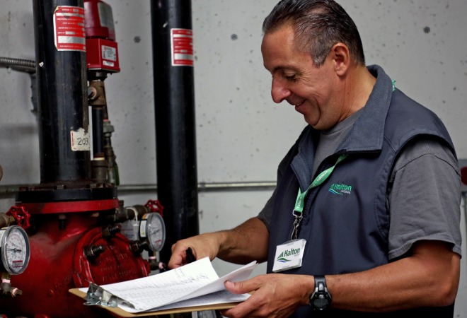 A Regional employee inspecting water pipes in a building.