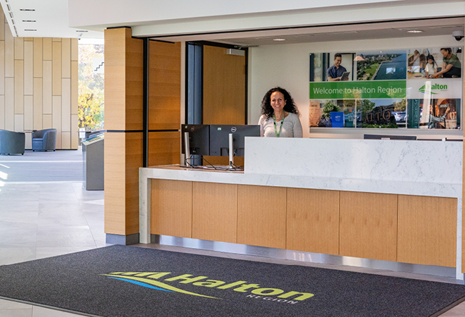 Access Halton customer service representative at a reception counter at Halton Regional Centre.