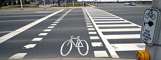 A cyclist crossride beside a pedestrian crosswalk at an intersection