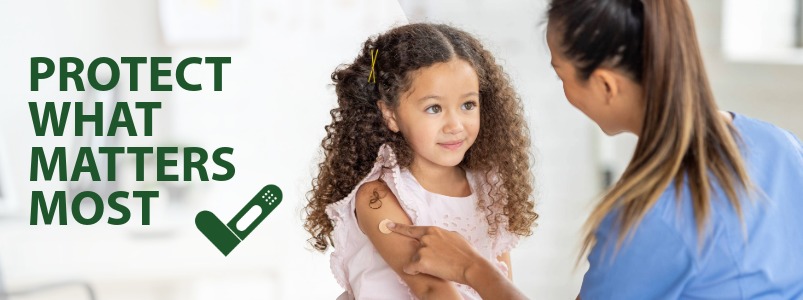 A health care worker placing a bandage on a recently vaccinated child.