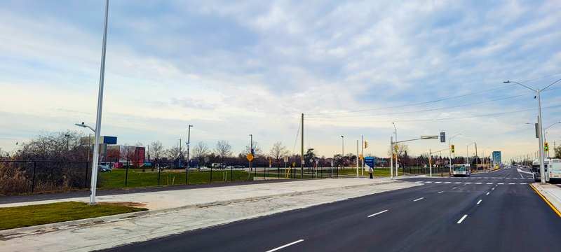 Entrance to Sheridan College at Ceremonial Road, showing the new bus bays, sidewalks, bike lanes, street lighting, traffic signals and wider roadway.