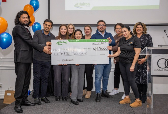 The nine grant winners posing for a group photo, holding a large cheque for $45,000.