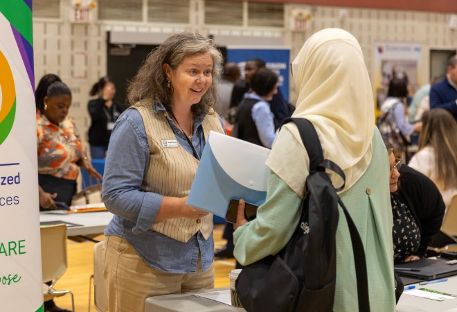 An employer speaks to a job fair attendee.