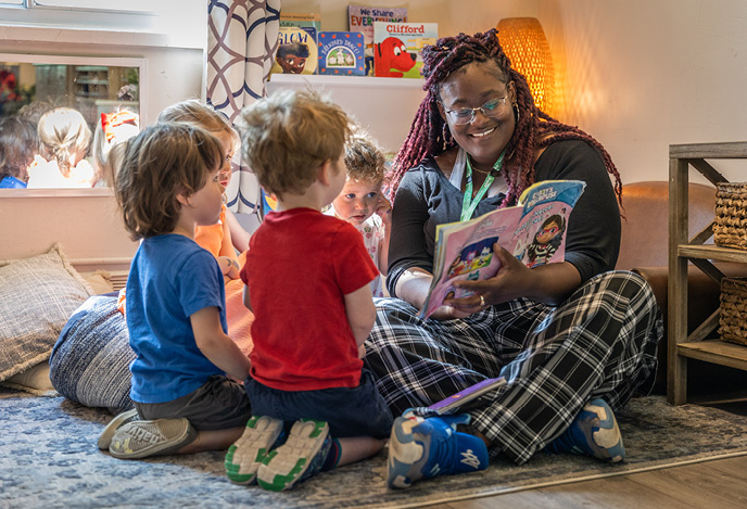 A child care worker reading to children.