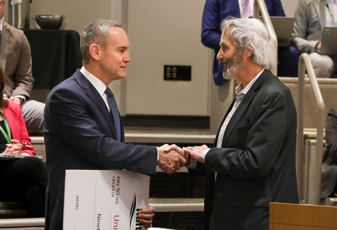 Brad Park and Gary Carr shaking hands in Council Chambers.