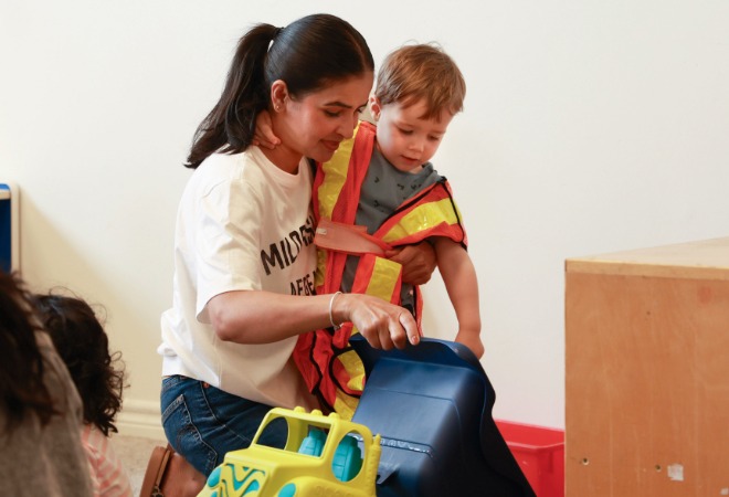 Early childhood educator with child in a safety vest