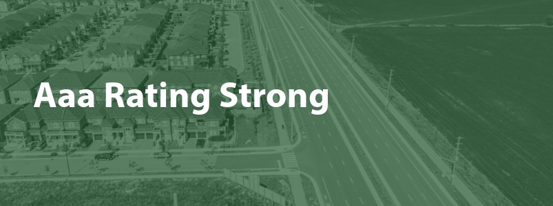 A drone photo of the community with the text "Aaa Rating Strong" superimposed.