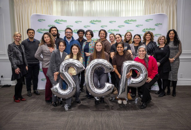 Group in front of balloons spelling out SCP